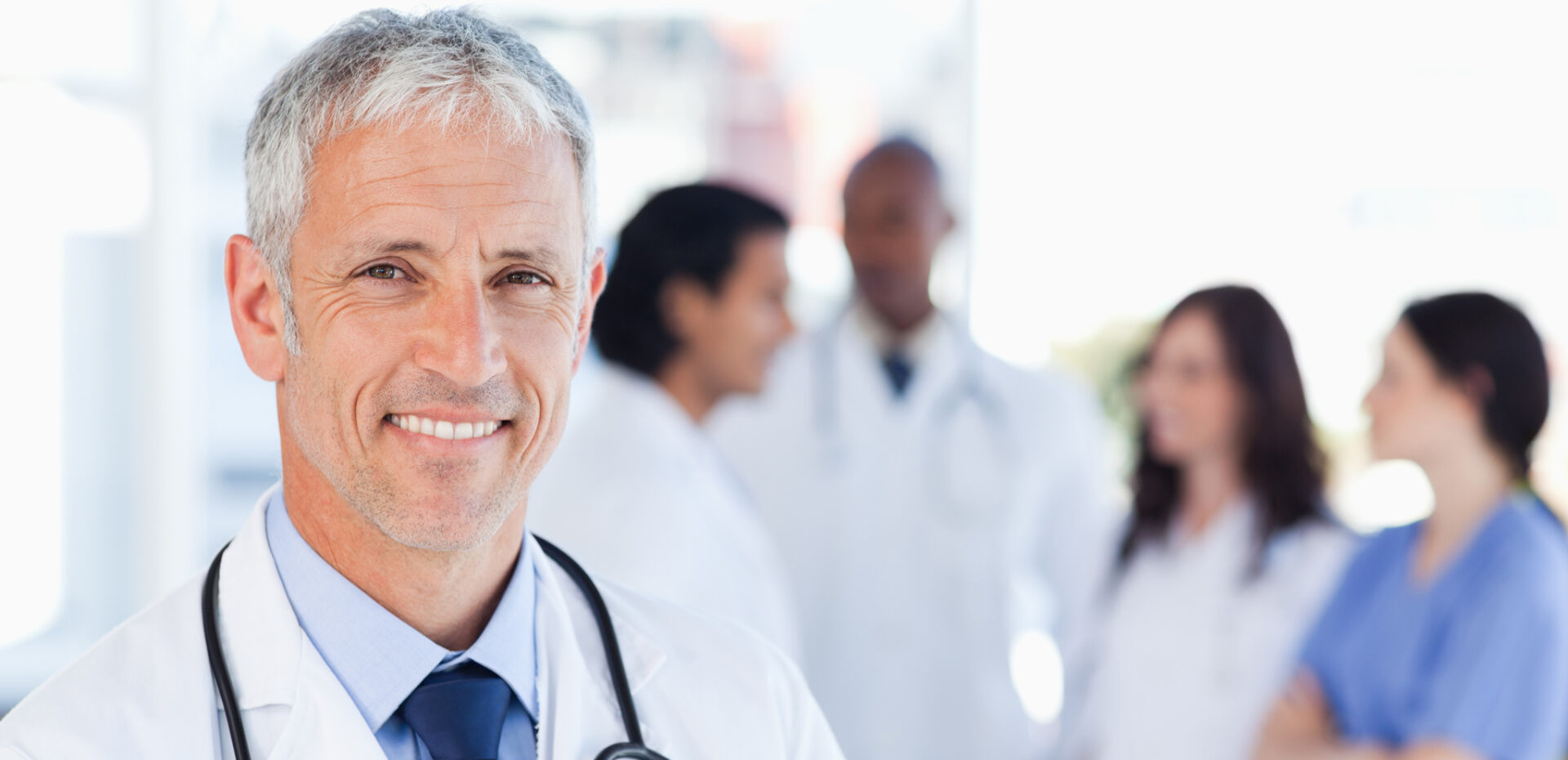 Gray haired doctor wearing stethoscope and smiling