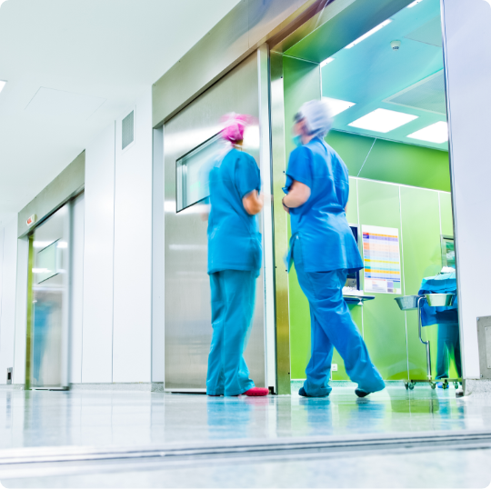 Two locum tenens providers in scrubs standing in hallway