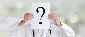 Doctor holding up question mark